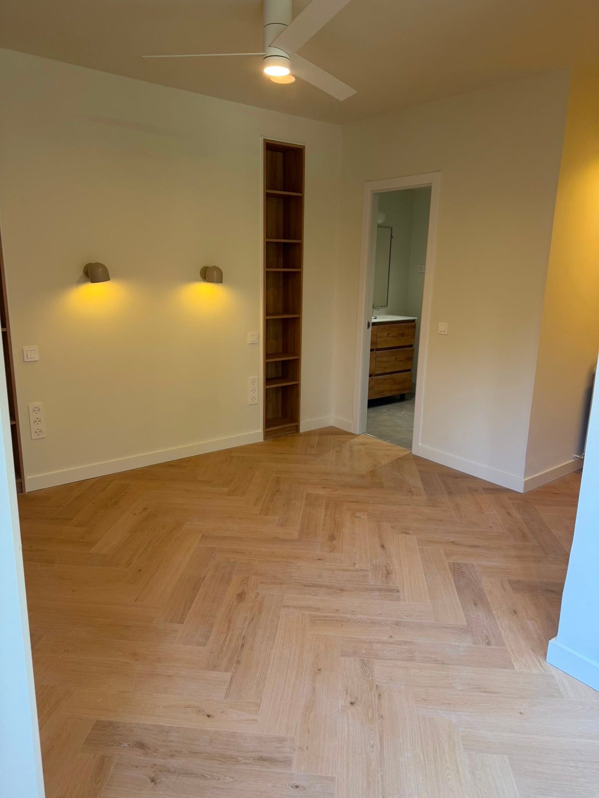 Dormitorio reformado con apliques de luz cálida