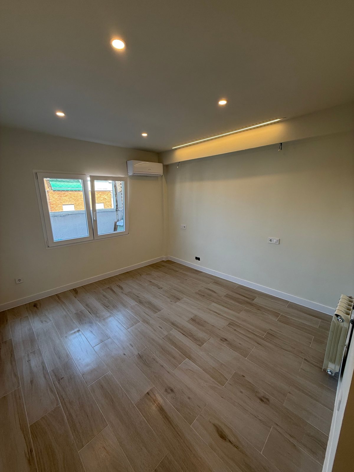 Habitación reformada con suelo porcelánico efecto madera